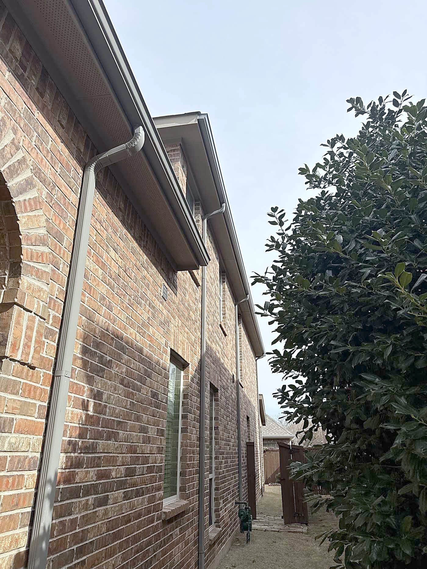 Downspouts along a brick side yard